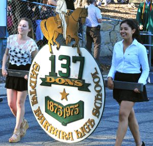 2 women carry an SBHS sign in a parade